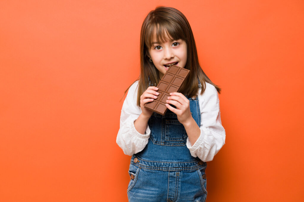 24 12 24 a child eating a large bar of chocolate mf dload gettyimages 1386514952 1200x800 5b2df79