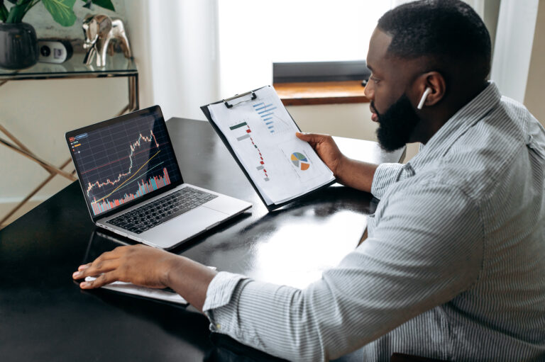 person looking at a computer with a stock price graph on it