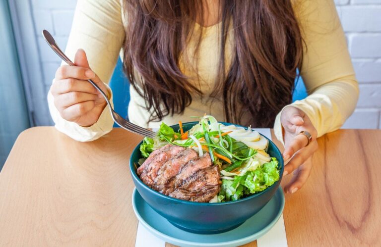 woman eating steak salad