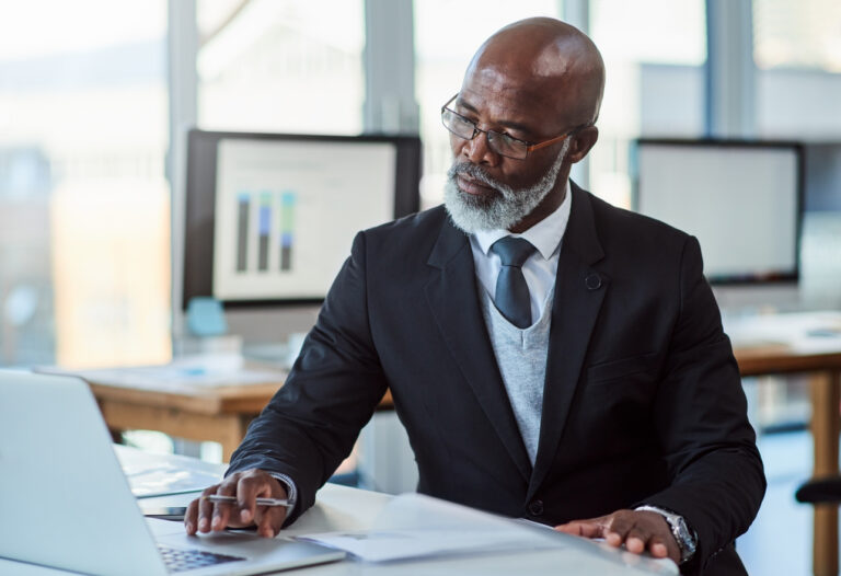 getty person in suit at desk laptop thoughtful thinking 1286x880 7c61f58