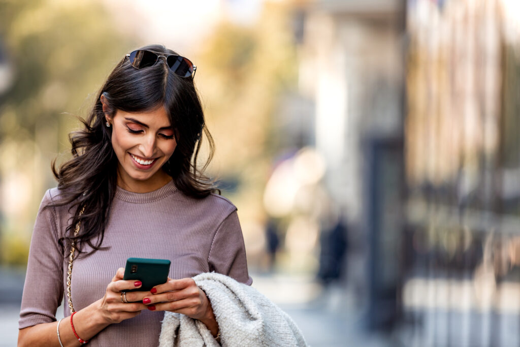 person looking at a phone and smiling