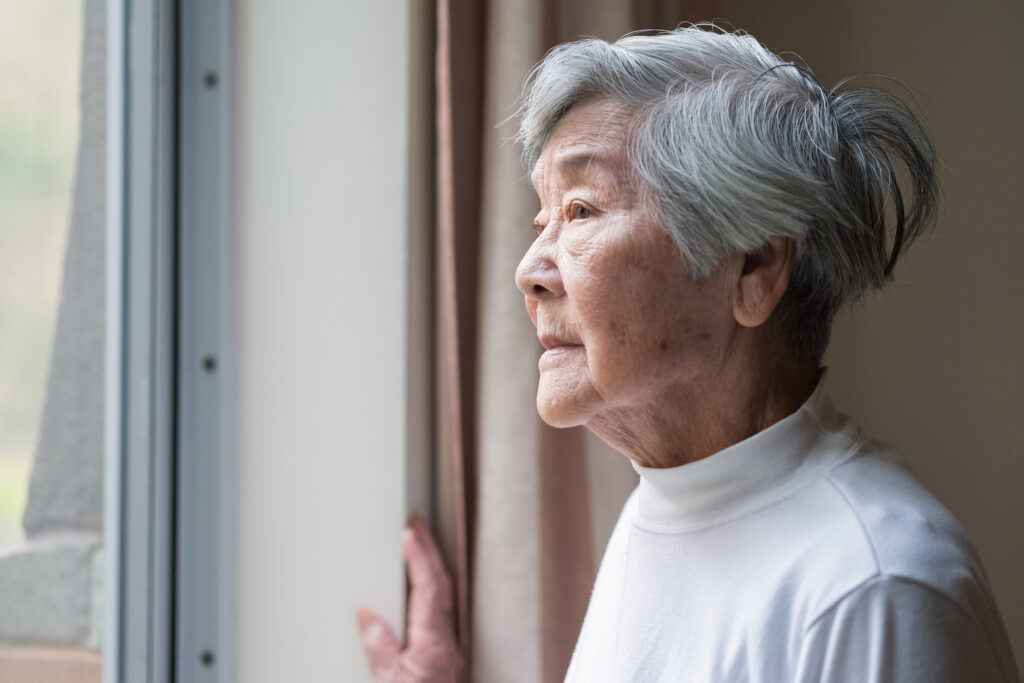 senior woman looking outside care facility