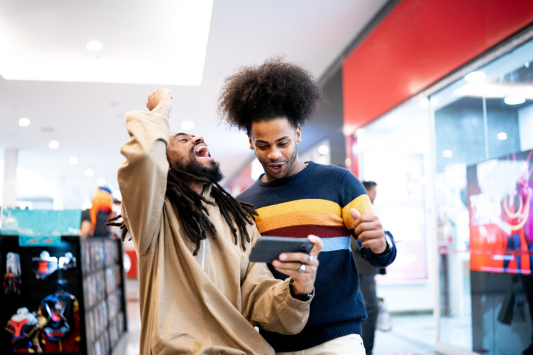 investors stand and cheer while looking at phone